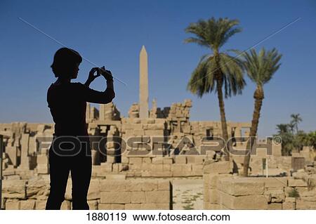 Silhouette Of Woman Photographing Ruins Of Karnak Temple View Large Photo Image Stock Photo - Silhouette Of Woman Photographing Ruins Of Karnak Temple. Fotosearch