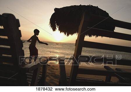 Silhouetted Boy Walking By Deckchairs And Umbrella View Large Photo Image Stock Image - Silhouetted Boy Walking By Deckchairs And Umbrella. Fotosearch