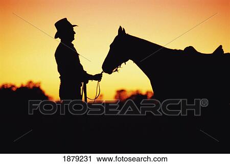 Stock Image - Silhouetted Cowboy And Horse, Australia. Fotosearch