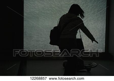 Stock Photo - Silhouetted female passenger runs with luggage, Charles de Gaulle Airport, Paris, France. Fotosearch