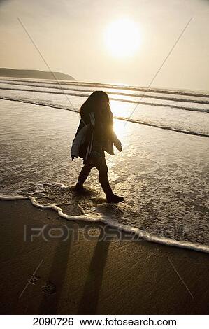 Silhouetted Female Walking On The Beach At Sunset In Putsborough Sands, North Devon, Uk View Large Photo Image Stock Photograph - Silhouetted Female Walking On The Beach At Sunset In Putsborough Sands, North Devon, Uk. Fotosearch