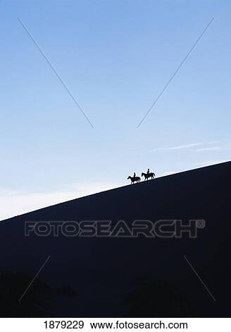 Silhouetted Horse Riders At Dusk On A Sand Dune In The Valle De La Muerte View Large Photo Image Stock Photo - Silhouetted Horse Riders At Dusk On A Sand Dune In The Valle De La Muerte. Fotosearch