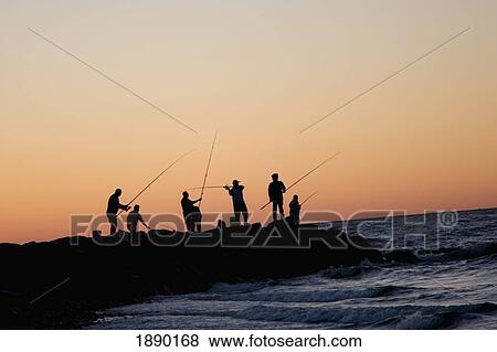 Silhouetted People Fishing Off Rocks On Beach At Sunset View Large Photo Image Stock Photo - Silhouetted People Fishing Off Rocks On Beach At Sunset. Fotosearch