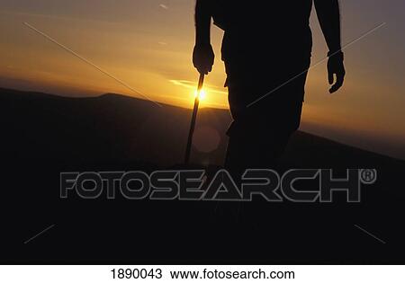 Silhouetted Walker On Black Mountain At Sunset, Low Angle View View Large Photo Image Stock Image - Silhouetted Walker On Black Mountain At Sunset, Low Angle View. Fotosearch