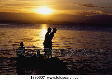 Silhouettes Of Boys On Rocks At Lake Taupo At Sunset View Large Photo Image Stock Photo - Silhouettes Of Boys On Rocks At Lake Taupo At Sunset. Fotosearch