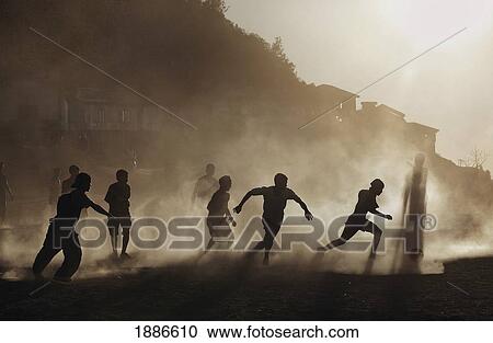 Silhouettes Of Mizo Boys Running On A Dusty Soccer Pitch At Sunset View Large Photo Image Stock Image - Silhouettes Of Mizo Boys Running On A Dusty Soccer Pitch At Sunset. Fotosearch