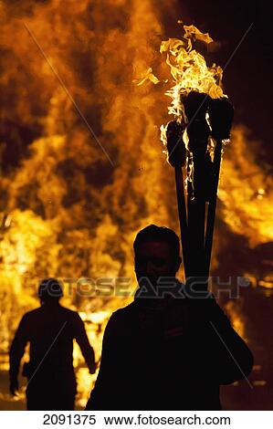 Silhouettes Of People Preparing To Throw Burning Torches On Large Bonfire At Barcombe Bonfire Night, Barcombe, East Sussex, Uk View Large Photo Image Stock Photography - Silhouettes Of People Preparing To Throw Burning Torches On Large Bonfire At Barcombe Bonfire Night, Barcombe, East Sussex, Uk. Fotosearch