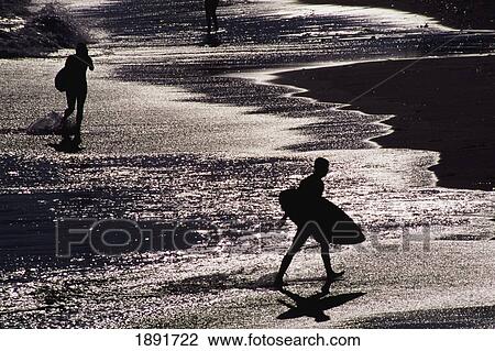 Stock Image - Silhouettes Of Surfers On Beach. Fotosearch