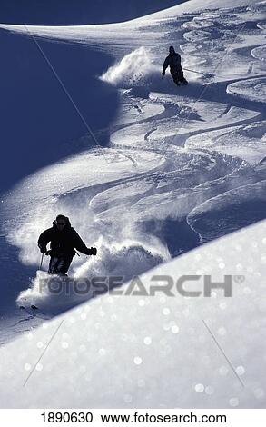 Stock Image - Silhouettes Of Two Skiers On Slope. Fotosearch