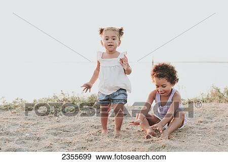 Sisters Playing On The Beach; British Columbia, Canada View Large Photo Image Stock Photo - Sisters Playing On The Beach; British Columbia, Canada. Fotosearch