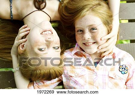 Sisters With Freckles And Red Hair Lay Facing Opposite Ways On A Porch. View Large Photo Image Stock Photo - Sisters With Freckles And Red Hair Lay Facing Opposite Ways On A Porch.. Fotosearch