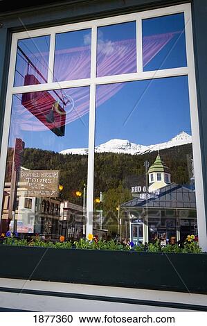 Stock Image - Skagway, Alaska, United States Of America; Reflection In The Window Of The Red Onion Saloon In Klondike Gold Rush National Historic Park. Fotosearch
