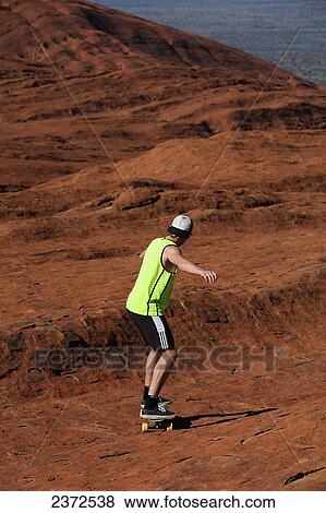 Stock Photo - Skateboarding on Uluru, formerly known as Ayers Rock; Northern Territory, Australia. Fotosearch