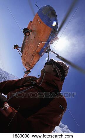 Skier And Helicopter, Low Angle View View Large Photo Image Stock Photo - Skier And Helicopter, Low Angle View. Fotosearch