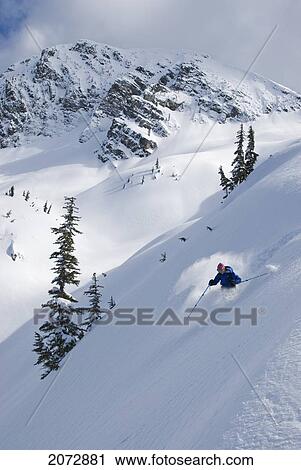 Stock Image - Skier Hitting Powder Below Nak Peak, Thar Basin, Cascade Mountains, British Columbia. Fotosearch
