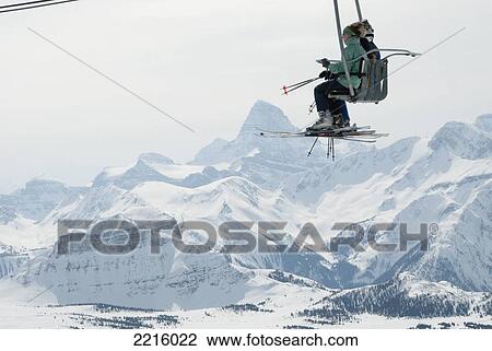 Skiers On Ski Lift With Mt. Assiniboine At Sunshine Village Ski Resort In The Canadian Rockies View Large Photo Image Stock Image - Skiers On Ski Lift With Mt. Assiniboine At Sunshine Village Ski Resort In The Canadian Rockies. Fotosearch