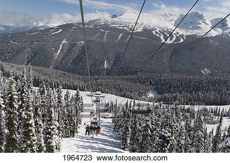 Skiers Riding A Chairlift At A Ski Resort; Whistler British Columbia Canada View Large Photo Image Stock Image - Skiers Riding A Chairlift At A Ski Resort; Whistler British Columbia Canada. Fotosearch