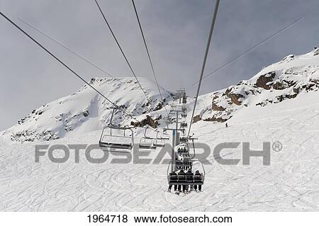 Skiers Riding A Chairlift At A Ski Resort; Whistler British Columbia Canada View Large Photo Image Stock Photo - Skiers Riding A Chairlift At A Ski Resort; Whistler British Columbia Canada. Fotosearch