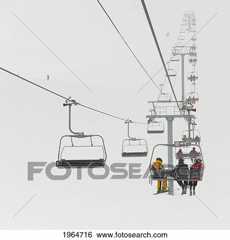 Stock Photograph - Skiers Riding A Chairlift At A Ski Resort; Whistler British Columbia Canada. Fotosearch