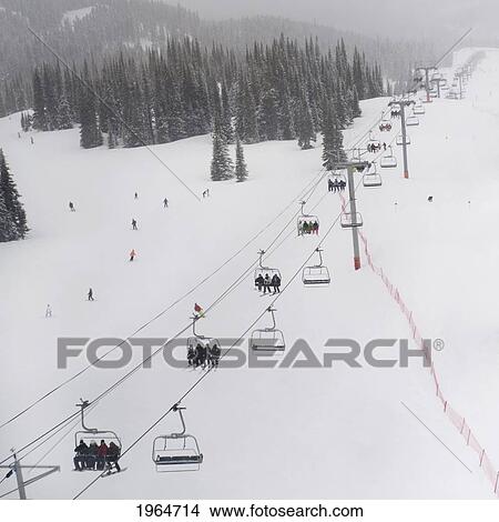 Skiers Riding The Chairlift At A Ski Resort; Whistler British Columbia Canada View Large Photo Image Picture - Skiers Riding The Chairlift At A Ski Resort; Whistler British Columbia Canada. Fotosearch