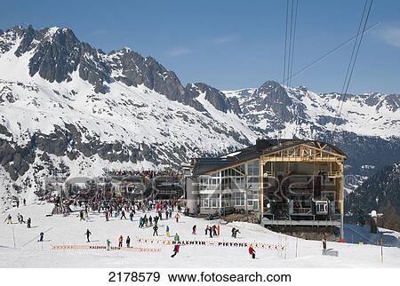 Stock Photo - Skiiers At A Resort By The Chalet At Bottom Of The Hill Where The Aerial Tramway Stops; Chaminox-Mont-Blanc Rhone-Alpes France. Fotosearch