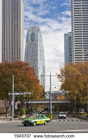 Stock Photo - Skyscapers Including Cocoon Tower And Cars On A Road; Shinjuku Tokyo Japan. Fotosearch