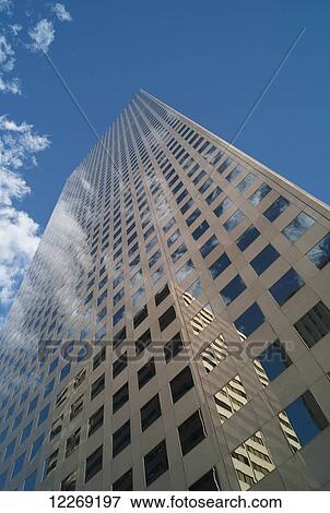 Stock Photo - Skyscraper reflecting another building in it's windows with blue sky and cloud; Denver, Colorado, United States of America. Fotosearch