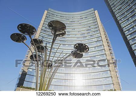 Stock Image - Skyscrapers and street lamp in financial district; Milan, Lombardy, Italy. Fotosearch