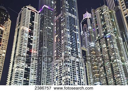 Stock Photo - Skyscrapers illuminated at nighttime; Dubai, United Arab Emirates. Fotosearch