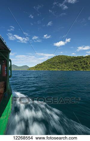 Picture - Small boat going past island off Cape Maclear, Lake Malawi; Malawi. Fotosearch