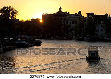 Small boat on canal at dusk; Amsterdam, Holland View Large Photo Image Stock Photography - Small boat on canal at dusk; Amsterdam, Holland. Fotosearch