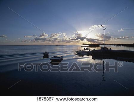 Stock Photo - Small Boat Pulling Into Mcleans Town Harbor At Dusk. Fotosearch
