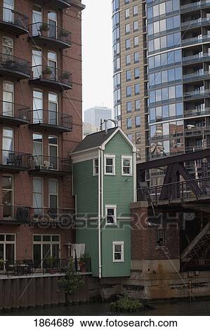 Stock Photo - Small Green House Among Tall Buildings, Chicago, Illinois, Usa. Fotosearch