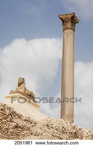 Stock Image - Small Sphinx And Column Of Red Granite 30M Tall, Erected In 298 Ad In Honour Of The Emperor Diocletian On The Acropolis Of Alexandria. It Was Wrongly Named PompeyÃƒÆ’Ã¢â‚¬Â S Pillar By Travellers During The Middle Ages, Alexandria, Al Iskandar. Fotosearch
