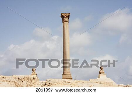 Stock Photo - Small Sphinxes And Column Of Red Granite 30M Tall, Erected In 298 Ad In Honour Of The Emperor Diocletian On The Acropolis Of Alexandria. It Was Wrongly Named PompeyÃƒÆ’Ã¢â‚¬Â S Pillar By Travellers During The Middle Ages, Alexandria, Al Iskandar. Fotosearch
