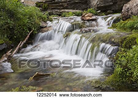 Small waterfalls in a stream with rocky ledge in the background; Waterton, Alberta, Canada View Large Photo Image Picture - Small waterfalls in a stream with rocky ledge in the background; Waterton, Alberta, Canada. Fotosearch