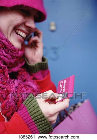 Smiling Woman In Pink Holding Credit Card While Talking On Mobile View Large Photo Image Stock Image - Smiling Woman In Pink Holding Credit Card While Talking On Mobile. Fotosearch