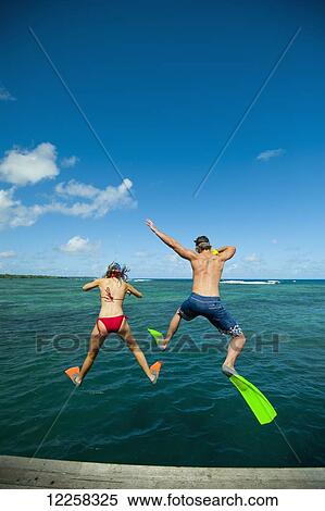 Stock Photography - Snorkellers jumping into the waters off Uplulu Island; Upulu, Samoa. Fotosearch