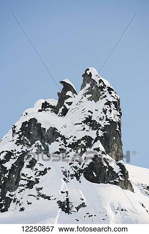Snow capped mountain peak against a blue sky; Haines, Alaska, United States of America View Large Photo Image Stock Photo - Snow capped mountain peak against a blue sky; Haines, Alaska, United States of America. Fotosearch