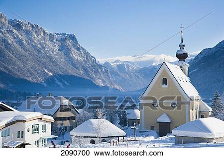 Stock Image - Snow Covered Alpine Scenery With Mountains, Picturesque Church, Ski And Snowboard Resort At Waidring, Austrian Alps, Austria. Fotosearch