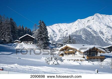 Snow Covered Alpine Scenery, With Mountains, Pine Trees, And Picturesque Ski Chalets At Ski And Snowboard Resort In Waidring, Austrian Alps, Austria View Large Photo Image Stock Photo - Snow Covered Alpine Scenery, With Mountains, Pine Trees, And Picturesque Ski Chalets At Ski And Snowboard Resort In Waidring, Austrian Alps, Austria. Fotosearch