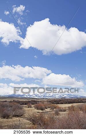 Snow Covered Mountains With Blue Sky And White Clouds Near Bozeman; Montana United States Of America View Large Photo Image Stock Photography - Snow Covered Mountains With Blue Sky And White Clouds Near Bozeman; Montana United States Of America. Fotosearch