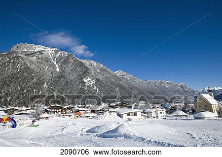 Snow Covered Village With Mountains And Picturesque Church In A Valley Below Ski Slopes At Waidring, Austrian Alps, Austria View Large Photo Image Stock Photograph - Snow Covered Village With Mountains And Picturesque Church In A Valley Below Ski Slopes At Waidring, Austrian Alps, Austria. Fotosearch