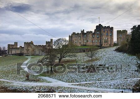 Stock Image - Snow On The Hills In Front Of Alnwick Castle; Alnwick Northumberland England. Fotosearch