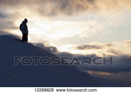 Stock Photo - Snowboarder silhouetted on a mountain, St. Moritz, Switzerland. Fotosearch