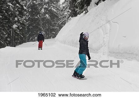 Stock Image - Snowboarding And Skiing On A Snowy Hill; Whistler British Columbia Canada. Fotosearch
