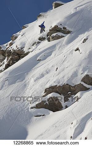 Stock Photography - Snowboarding down steep slope; Methven, New Zealand. Fotosearch