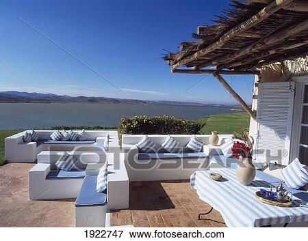 Stock Photo - Sofas On Patio Outside House Near Coast. Fotosearch