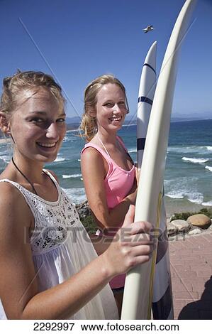 Stock Photo - South Africa, Garden Route, Girls Holding Surfboards On Beach; Plettenberg Bay. Fotosearch