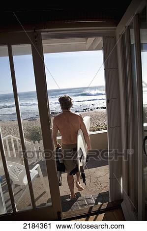 Stock Image - South Africa, Man Going For Surf At Pinnacle Point; Mossel Bay. Fotosearch